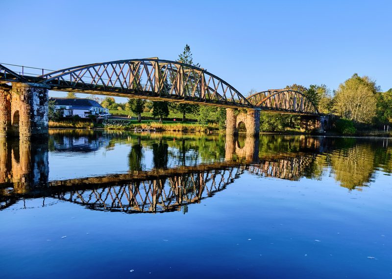 Uma vista pitoresca de uma velha ponte refletida em Loch Ken, na Escócia
