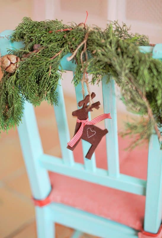Decore cadeiras com folhagens de inverno e enfeites de Natal
